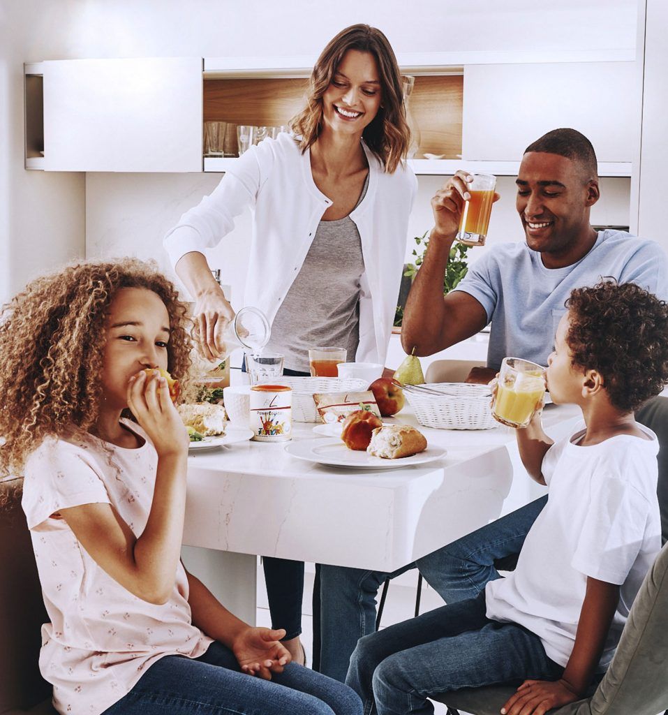 Una familia disfrutando de comida saludable con FitLine PowerCoctail y PowerCoctail Junior en la cocina